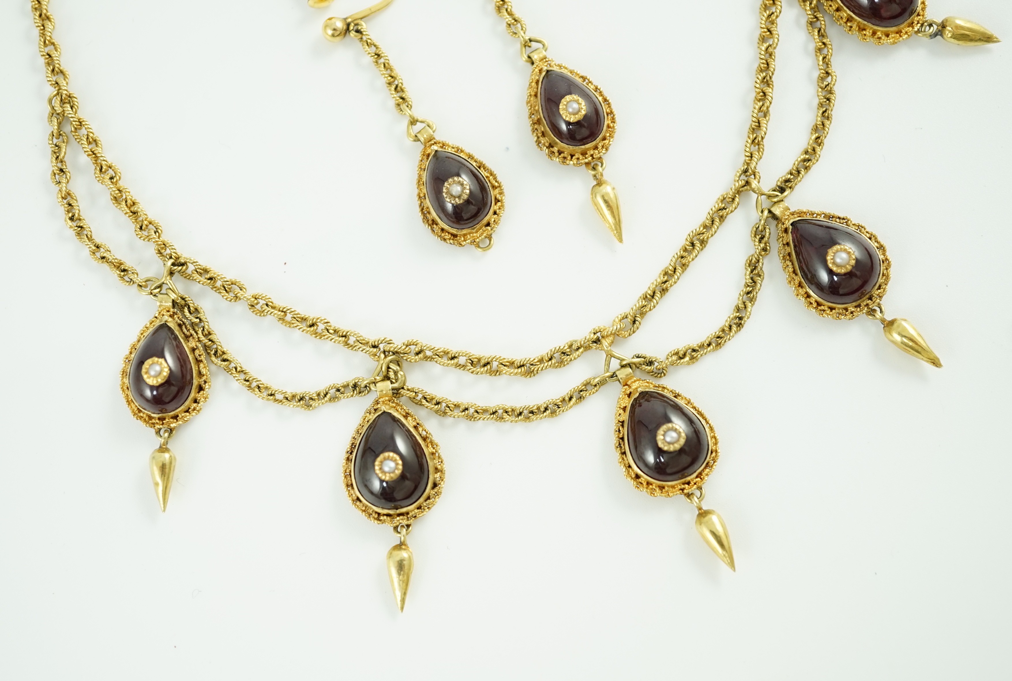 A 19th century Indian gold, garnet and seed pearl set demi parure, comprising and a drop fringe necklace and pair of matching ear clips